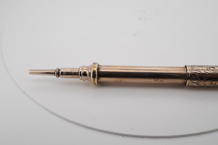 A 9ct gold propelling toothpick, 50mm and a yellow metal propelling pencil.